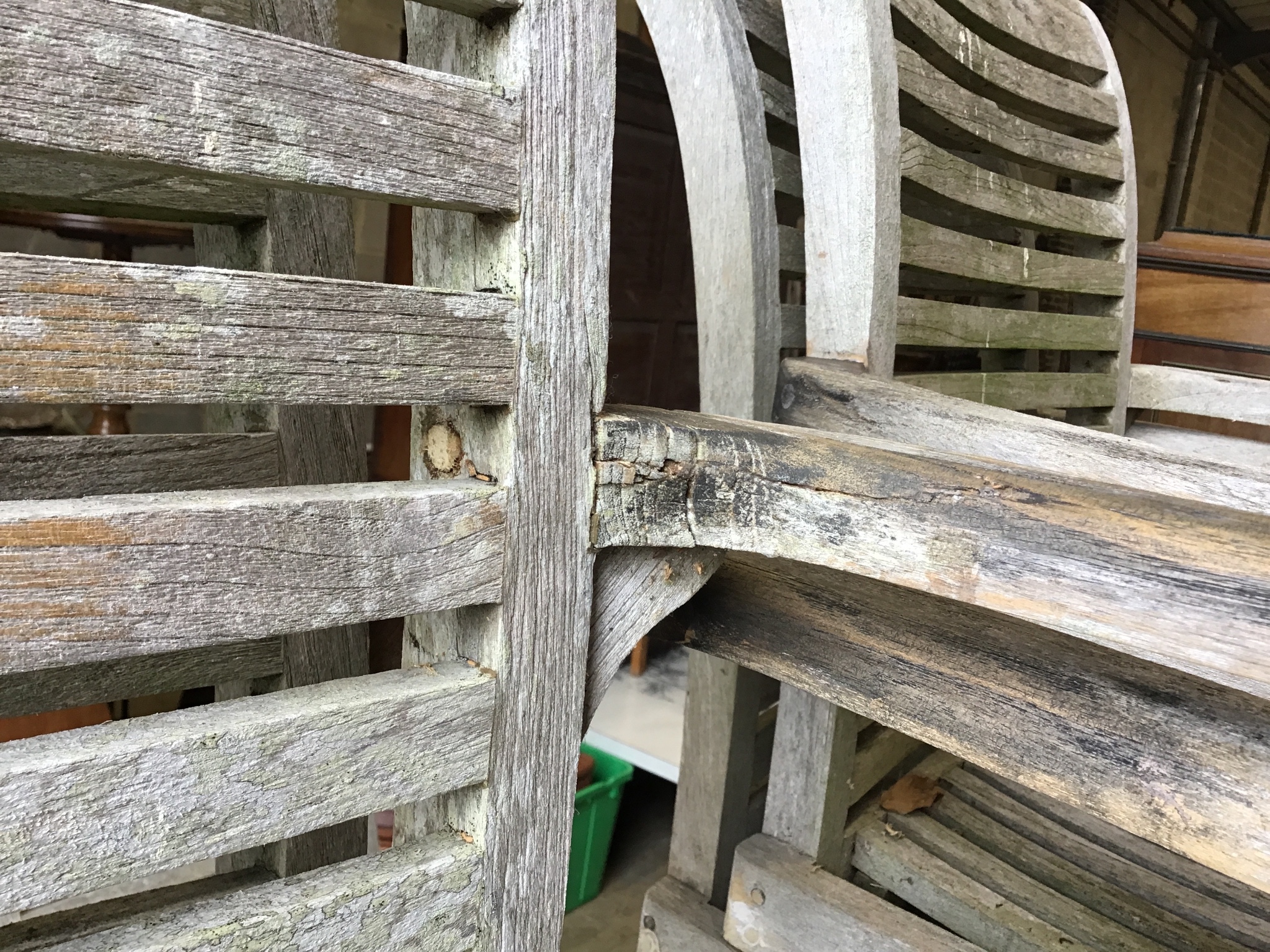 A weathered teak oval extending garden table, 242 cm extended, width 102 cm, height 73 cm and six stacking elbow chairs.